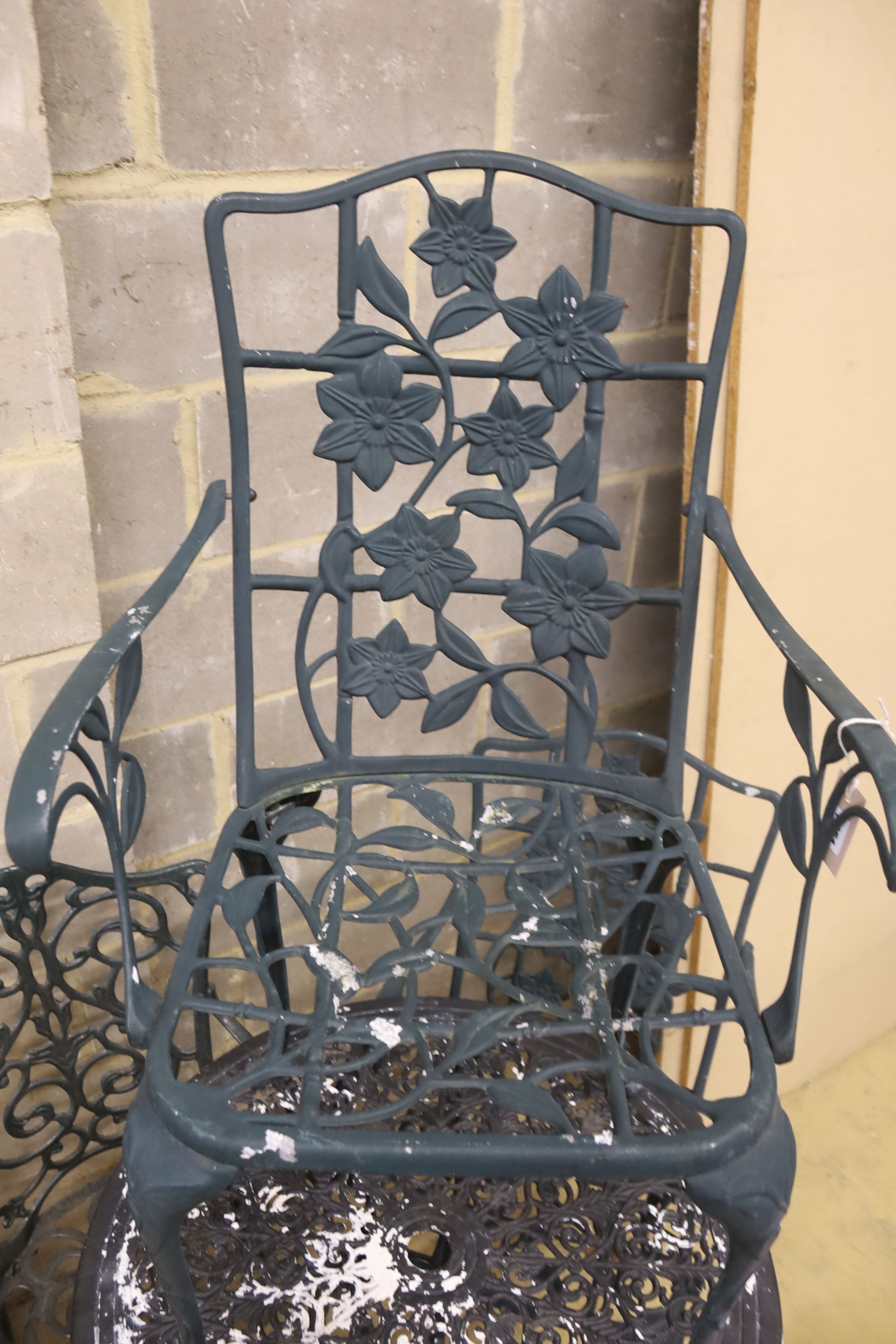 A painted aluminium circular garden table, 69cm diameter together with three chairs